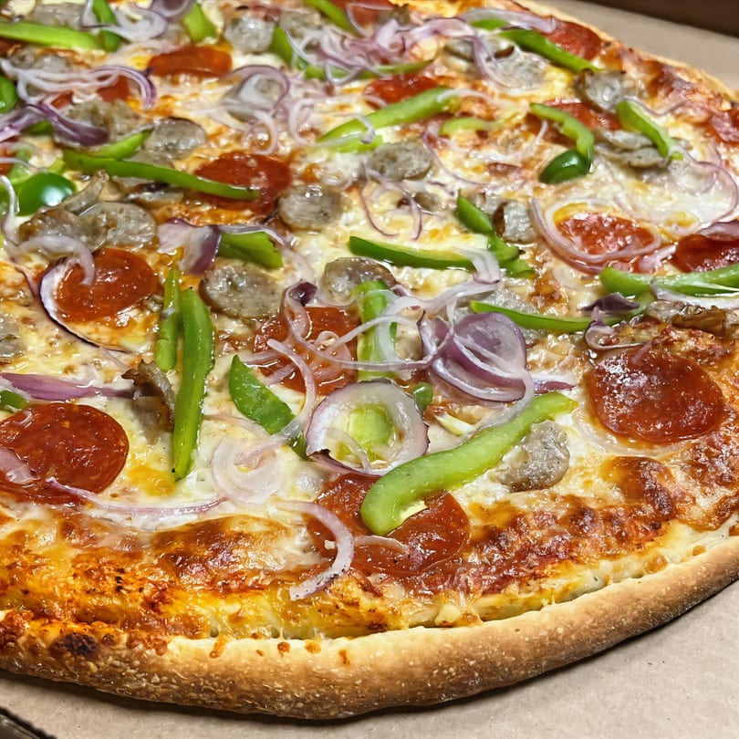 Di Angelo Pizza with pepperoni, sausage, green peppers, and red onions.